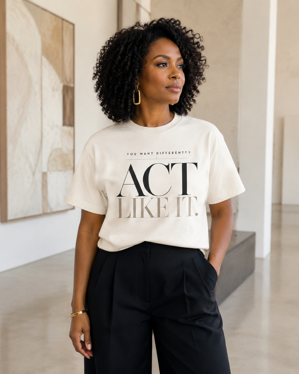 African American woman wearing the Act Like It statement tee in ivory with black tailored trousers