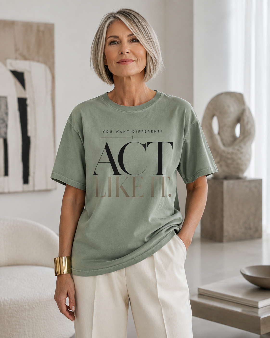 Woman wearing the Act Like It statement tee in sage with cream tailored trousers