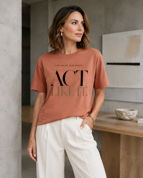 Woman wearing the Act Like It statement tee in terracotta with cream tailored trousers