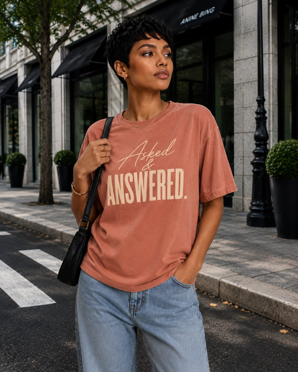 Woman wearing the Asked & Answered Comfort Colors Terracotta tee with relaxed denim on a city street.
