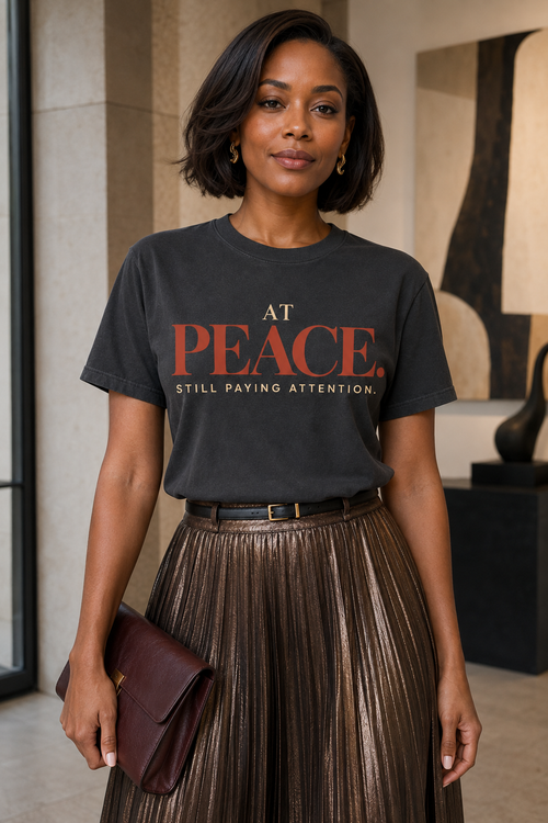 Black woman wearing the At Peace Still Paying Attention Comfort Colors Graphite statement tee in a close editorial lifestyle mockup
