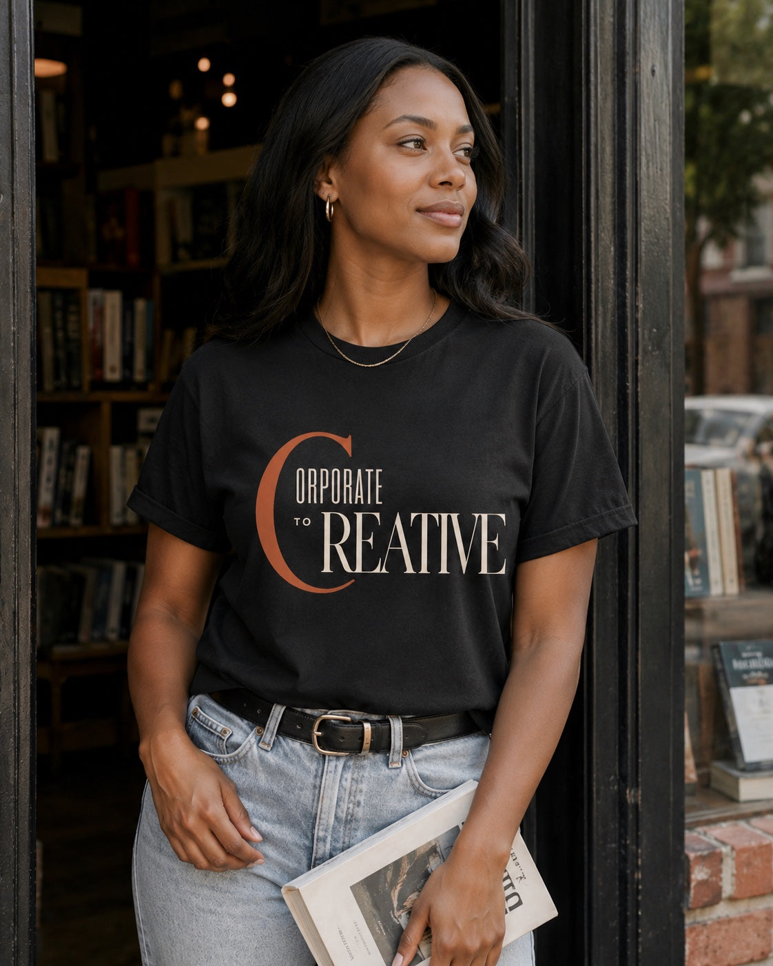 Woman wearing the Corporate to Creative statement tee in Comfort Colors Black at an independent bookstore