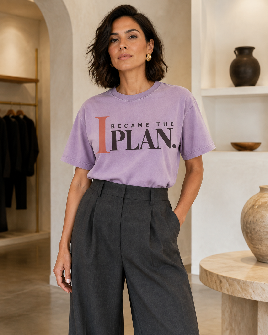 Hispanic woman wearing the I Became the Plan statement tee in orchid with charcoal tailored trousers