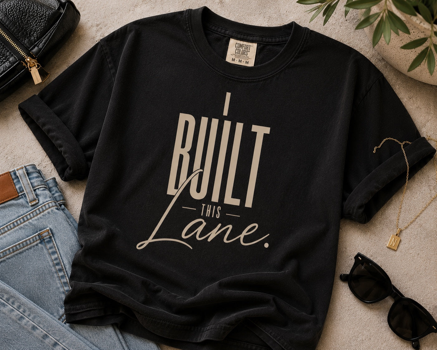 I Built This Lane black statement tee flat lay with neutral accessories