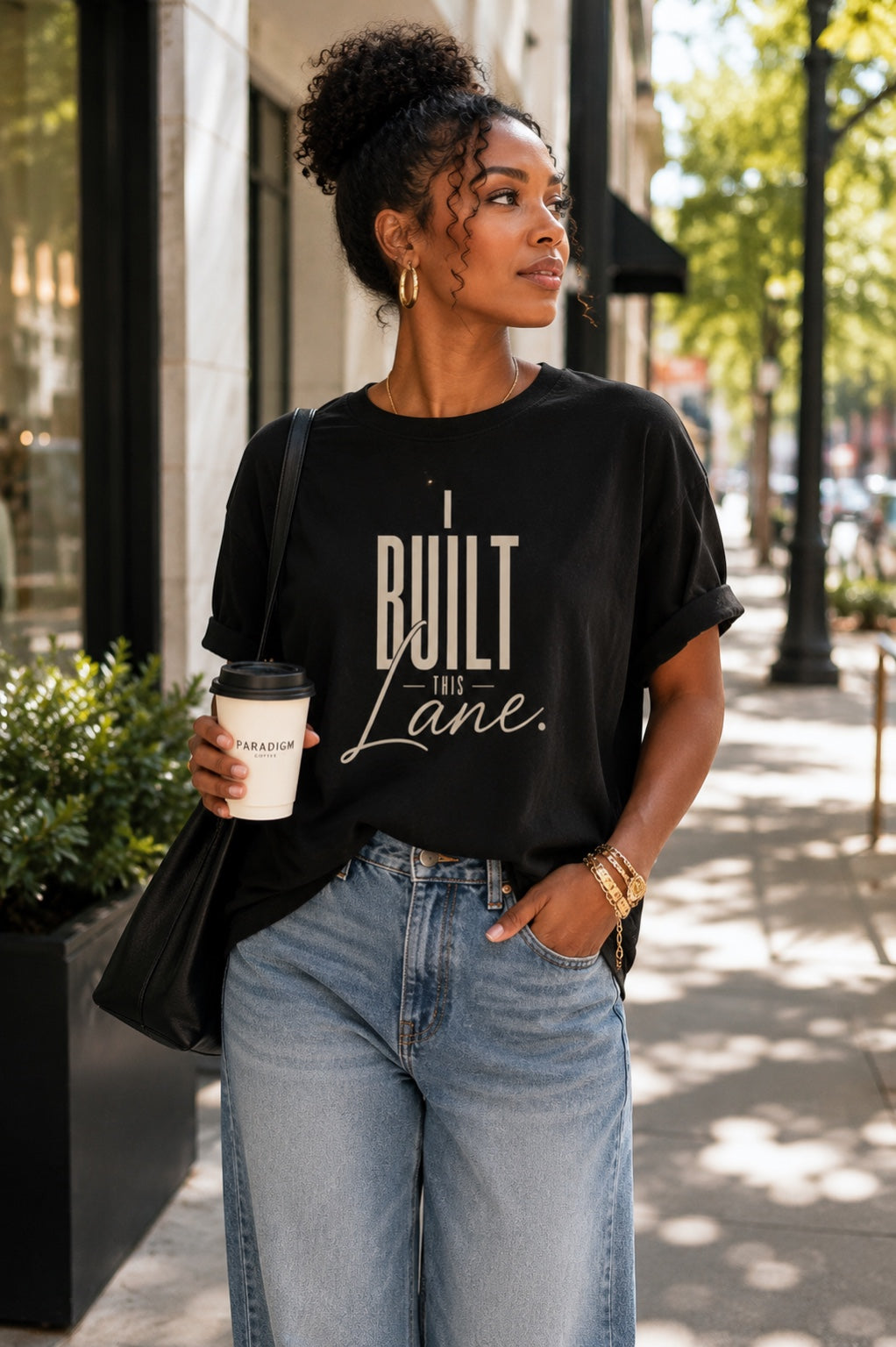 Woman wearing the I Built This Lane black statement tee with relaxed denim