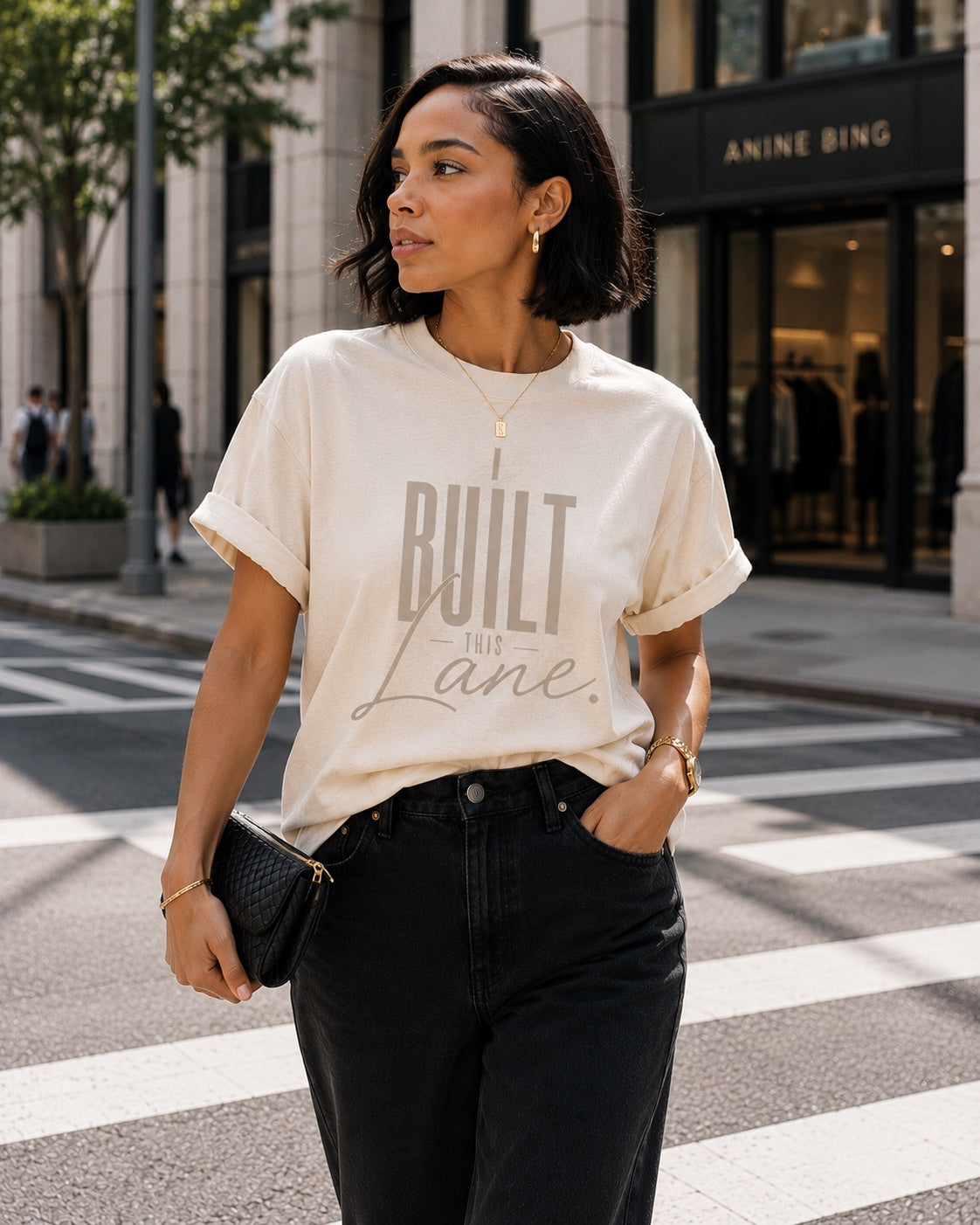 Woman wearing the I Built This Lane ivory statement tee with black jeans