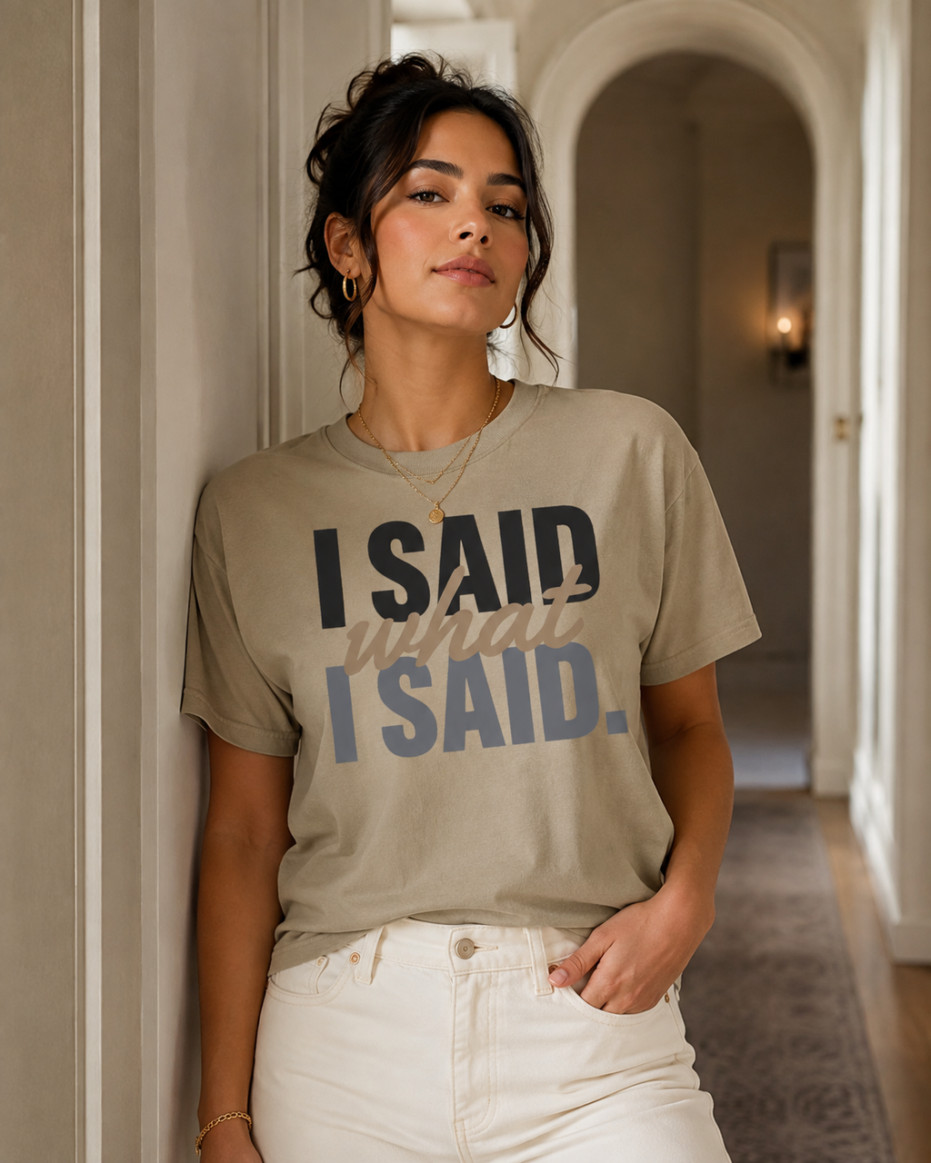 Woman wearing the I Said What I Said statement tee in Comfort Colors Khaki in a refined interior hallway.