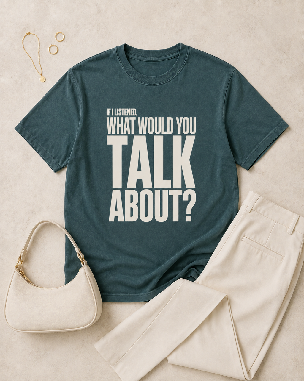 Blue spruce statement tee flat lay with cream trousers and neutral accessories