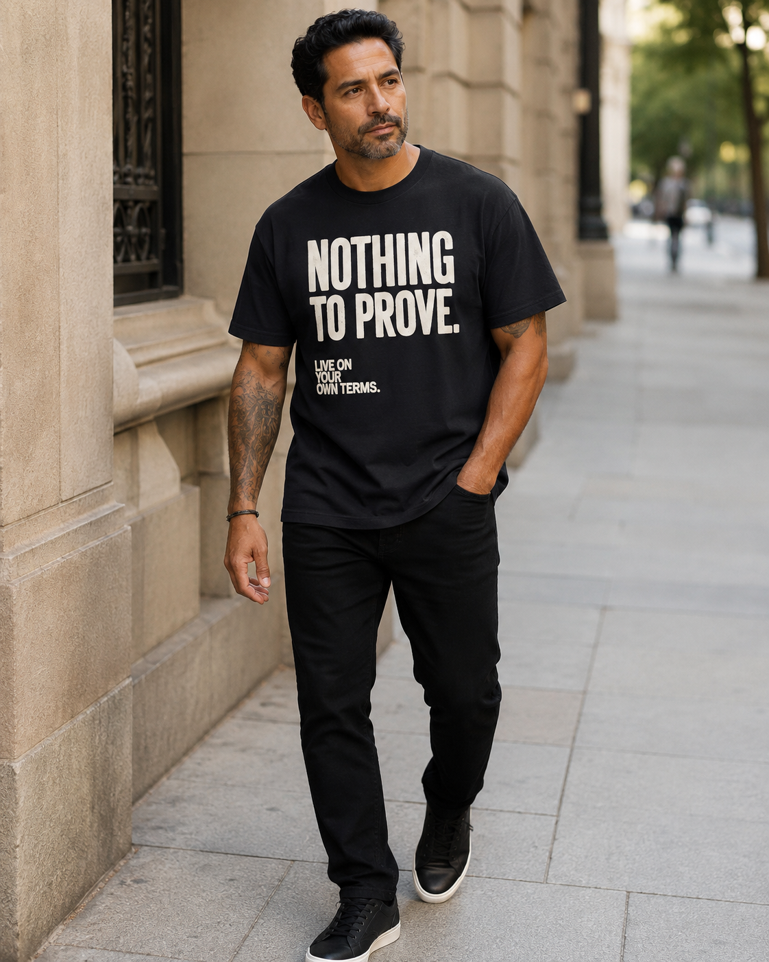 Man wearing black Nothing to Prove graphic tee with black jeans in an editorial city setting