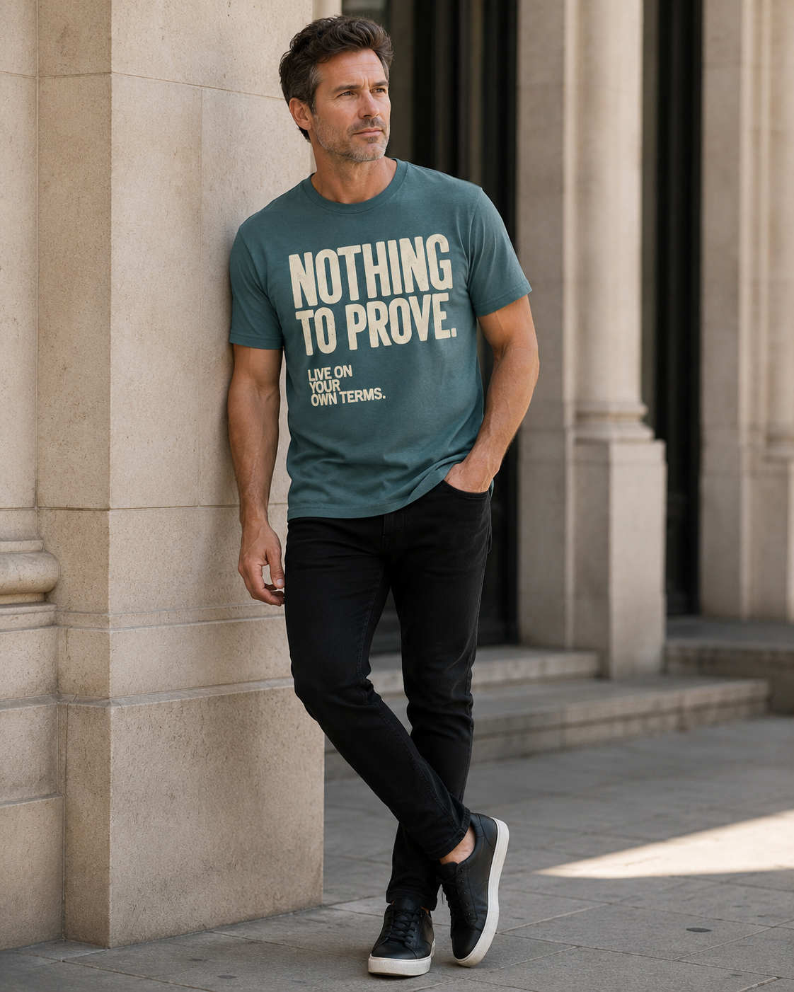 Man wearing Blue Spruce Nothing to Prove men's graphic tee with black jeans in an editorial city setting