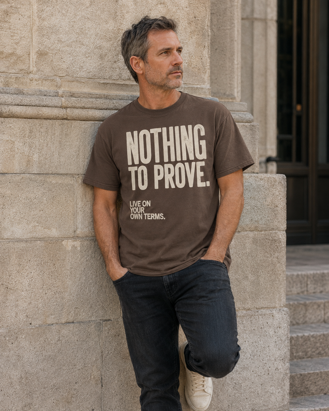 Man wearing Espresso Nothing to Prove men's graphic tee with dark jeans in an editorial city setting