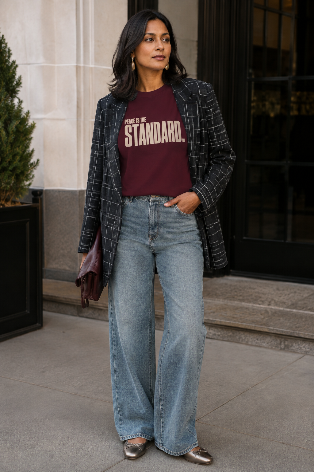 South Asian woman wearing the Peace Is the Standard Comfort Colors Wine statement tee with a windowpane blazer and wide-leg denim.