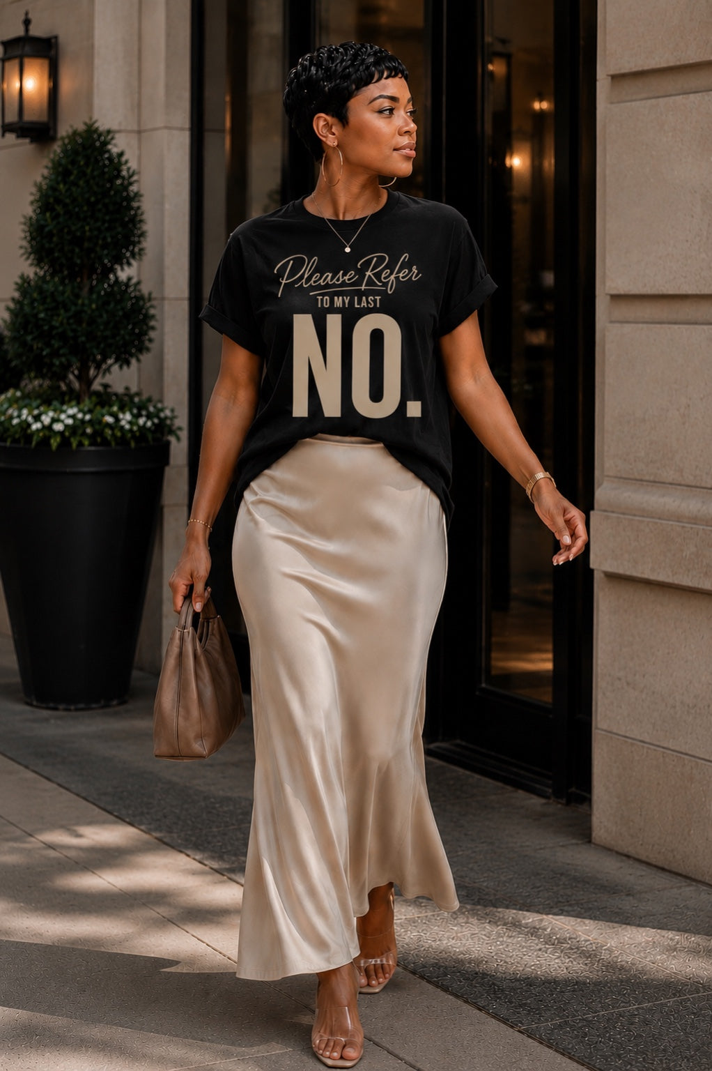 Woman wearing the Please Refer to My Last No. black statement tee with an ivory satin skirt.