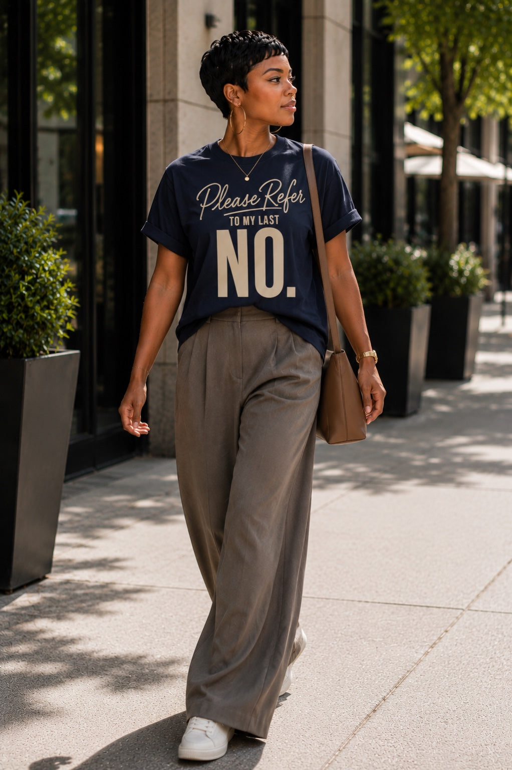 Woman walking in the Please Refer to My Last No. Comfort Colors Midnight Navy tee with wide-leg trousers and white sneakers.