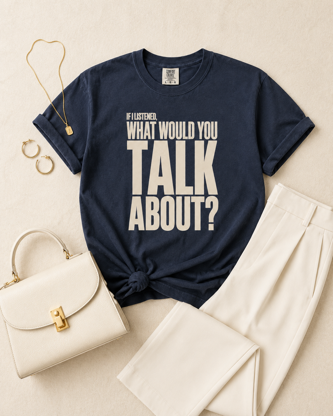 Midnight navy statement tee flat lay with cream trousers and gold accessories