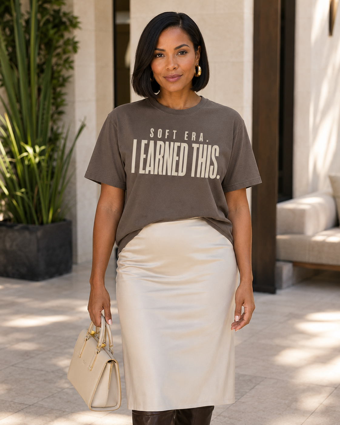 Woman wearing the Soft Era I Earned This statement tee in Comfort Colors Espresso