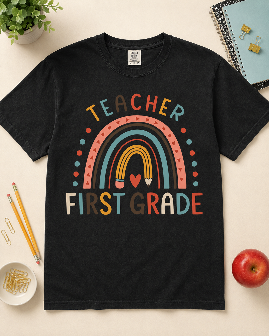 First Grade rainbow teacher tee Black Comfort Colors styled flat lay
