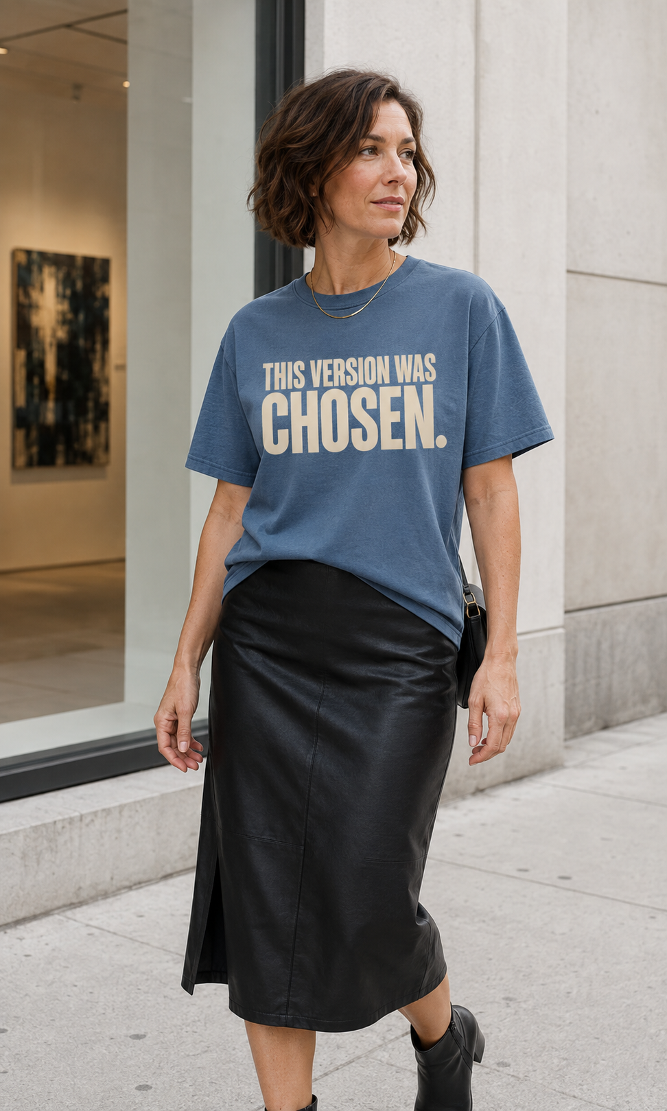 Caucasian woman wearing the This Version Was Chosen statement tee in blue jean with cream typography