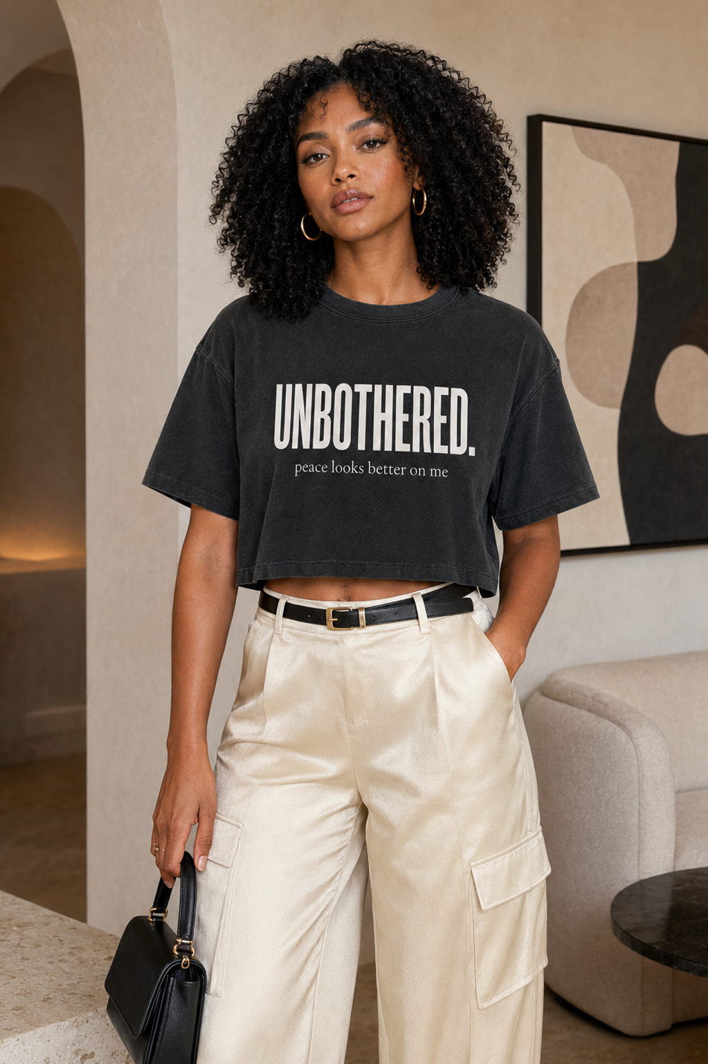 Black woman wearing the Unbothered washed black cropped statement tee in a close editorial lifestyle mockup